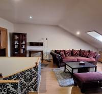 Nappali kanapékkal és mintás falakkal, fa dekorációjú padlóval.