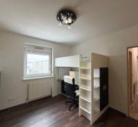 Gyerekszoba egy háromszobás lakásban emeletes ággyal és fa dekor padlóval.