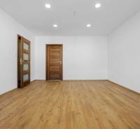 Egy 3 szobás lakás szobája fa mintás padlóval és fa ajtókkal.