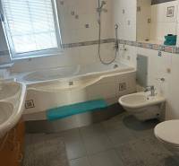 Fürdőszoba családi házban káddal, bidével és csempékkel.