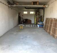 Garázs egy háromszobás lakásban tárolt tárgyakkal és kerékpárral.