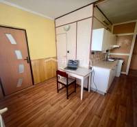 Konyha egy háromszobás lakásban étkező sarokkal és fa padlóval.