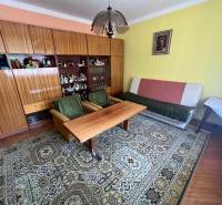 Nappali egy családi házban bútorokkal, szőnyeggel és képpel a falon.