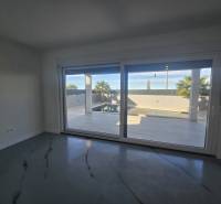 Egy nagy üvegezésű villa belső tere, kilátással a külső medencére.