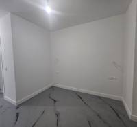 Üres szoba a Villában fehér falakkal és márvány mintás padlóval.