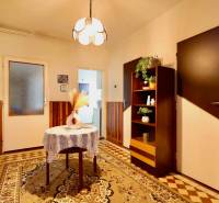 Családi ház belső tere szőnyegpadlóval, a háttérben szekrény és világítás.