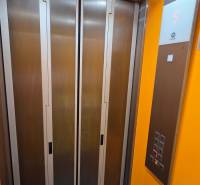 Lift az épületben, gombokkal és egy kijelzővel, amely az ötödik emeletet mutatja.