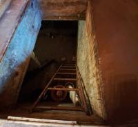 Kilátás a pince nyílására lépcsőkkel a Záhradách belső terében.