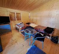 Szoba fa falakkal, ágyakkal, televízióval és fa dekorációjú padlóval.