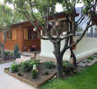 Egy fából készült kerti házikó zölddel körülvéve az alsókrškani kertekben, Nyitrán.