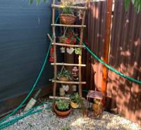 Kertek Nyitra Alsókrškánban díszlétrával és virágtartókkal kavicsos alapon.