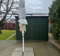 Kertek Alsókrškán, Nyitrán összecsukott napernyővel, szilárd burkolattal és gyepfelülettel.