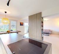 Nyitott belső tér családi házban konyhával, étkezővel és kényelmes nappali sarokkal.