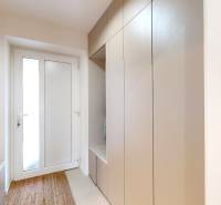 Családi ház előszobája akasztós szekrénnyel, tükörrel és szőnyeggel.