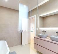 Fürdőszoba káddal, két mosdóval és tükörrel egy családi házban.