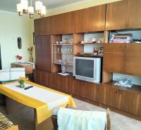 Nappali egy kétszobás lakásban fa dekor bútorokkal és retro televízióval.