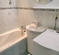 A kétszobás lakás fürdőszobája káddal, mosdóval és mosógéppel.