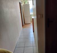 Folyosó hűtőszekrénnyel a kétszobás lakásban, csempe a padlón, világos falak.