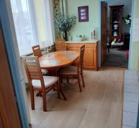 Étkező sarok egy kétszobás lakásban fa dekor padlóval és világos bútorokkal.