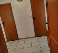 Előszoba egy kétszobás lakásban csempével és faajtókkal.