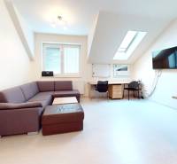 Irodák fa dekor padlóval, íróasztal, kanapé és képernyő a falon.