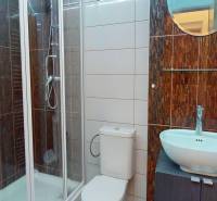 Fürdőszoba modern zuhanyzóval, mosdókagylóval a szekrényen és WC-vel az irodákban.