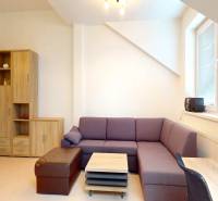 Az irodában a lila kanapé és a világos fa dekorációk dominálnak.