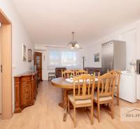 Ebédlő fa dekorációjú padlóval és bútorokkal egy háromszobás lakásban.