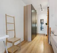 Az egyszobás lakás belső tere fa dekorációjú padlóval, szekrénnyel és ággyal.