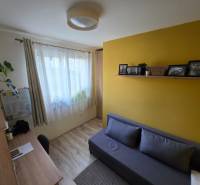 Szoba családi házban, fa dekorációs padlóval, íróasztallal és kanapéval.