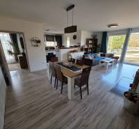 Nappali egy családi házban nyitott konyhával és fa dekorációjú padlóval.