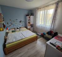 Gyerekszoba egy családi házban, fa dekorációs padlóval, ággyal és játékokkal.