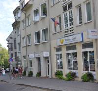 Egy utazási iroda irodájának épülete a pozsonyi Zámocká utcában, emberek csoportja a járdán.