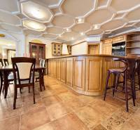 Konyha egy 4 szobás lakásban, étkezőasztallal, fa bútorokkal, csempével és érdekes mennyezettel.