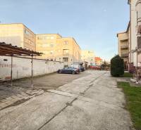 Parkoló a Hodžova utcai kétszobás lakásoknál Trencsénben, autókkal és zöldterülettel.