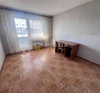 Szoba egy háromszobás lakásban, fa dekoros padlóval és nagy ablakokkal.