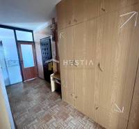 Folyosó egy 3 szobás lakásban, szekrénnyel és fa dekorációjú padlóval.