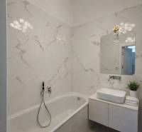 Fürdőszoba káddal, mosdóval, tükörrel és dekoratív lámpával egy háromszobás lakásban.