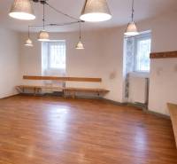 Kereskedelmi helyiség fa dekorációjú padlóval, padokkal és függő lámpákkal.