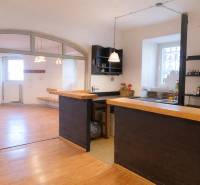 Üzlethelyiség bárpulttal és fa dekorációjú padlóval. Világos helyiség ablakokkal.