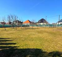 A Zemianska Olča családi házának kertje gyepes és gyümölcsfákkal van beültetve.