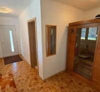 Egy családi ház folyosója fa dekorációs padlóval és beépített szaunával.