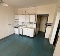 Konyhaszekrény egy egyszobás lakásban, fa dekorációjú padlóval.