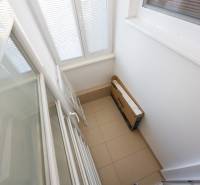 Erkély lehajtható ajtókkal és csempével egy kétszobás lakásban.