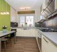 Konyha egy kétszobás lakásban, fa dekoros padlóval és zöld fallal.