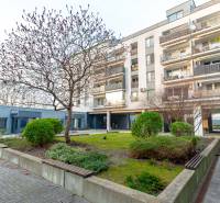 A Hrachova lakóház Pozsony-Ružinovban, zöldövezetben, fákkal és bokrokkal körülvéve.