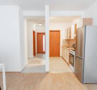 Konyha étkezőasztallal egy kétszobás lakásban, fa dekoros padlóval.