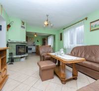 Családi ház nappalija bőr bútorokkal, kandallóval és teáskészlettel az asztalon.