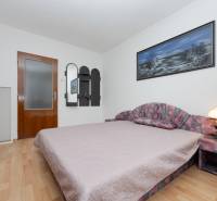 Hálószoba fa dekor padlóval egy családi házban, díszített képpel a falon.