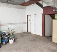 Családi ház garázs, elrakott szerszámok, betonpadló, lépcsők és fehér bútorok.